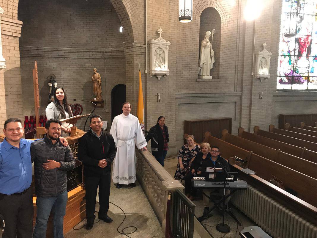 Un equipo de colaboradores asiste al vicario parroquial de la Basílica San Lorenzo en Asheville, Reverendo Padre David McCanless, en la transmisión de la Misa dominical por su flamante canal de YouTube.