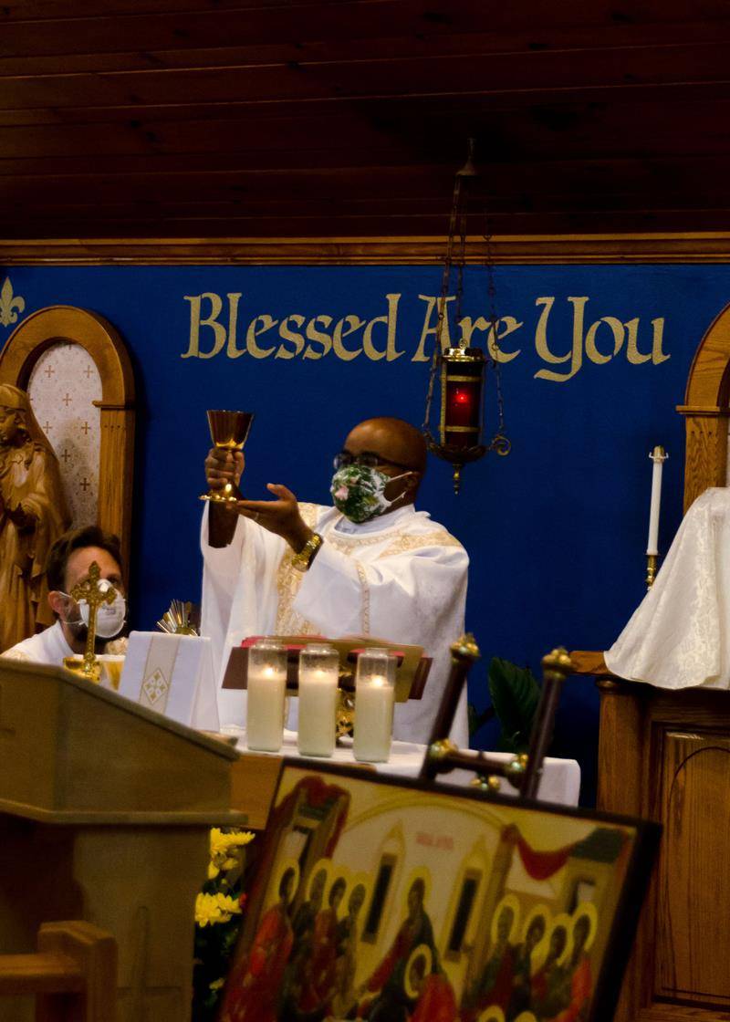 Missionaries of St. Paul Father Paul Asoh, pastor, elevates the Precious Blood during Mass at St. Mary, Mother of God Church’s parish-based Eucharistic Congress weekend of events Sept. 11-12 in Sylva. (Photo provided by Scott Freeman and St. Mary Parish)