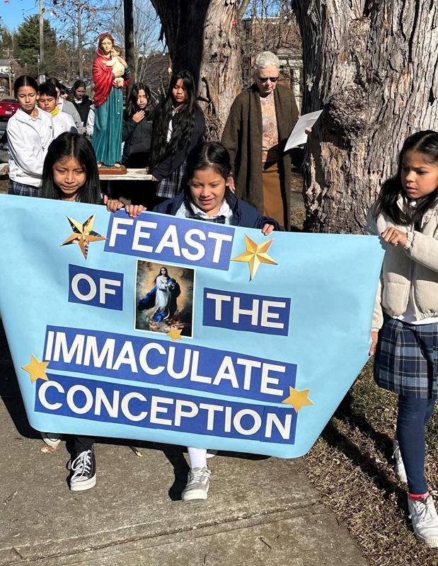 Students at Immaculata School participated in a procession in honor of the Feast of the Immaculate Conception on Dec. 8, carrying a statue of the Blessed Virgin Mary on a prayerful route around the block and back to the school. (Photo provided by Jay Silt