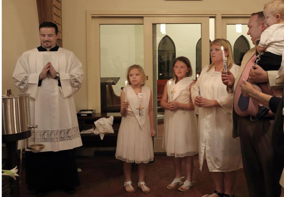 LENIOR — A mother and her three children were baptized at the Easter Vigil Mass at St. Francis of Assisi. Catechumen Courtney Walker, daughters Eisley and Courtney and 2-year-old son Dane Ryan were baptized. (By Giuliana Polinari Riley)